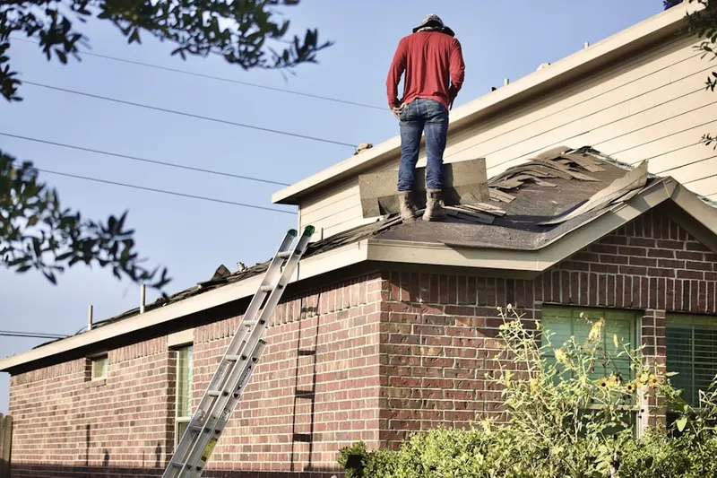 Professional roofer working on a residential roof in Highwood